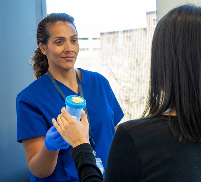 Nurse with urine collection cup